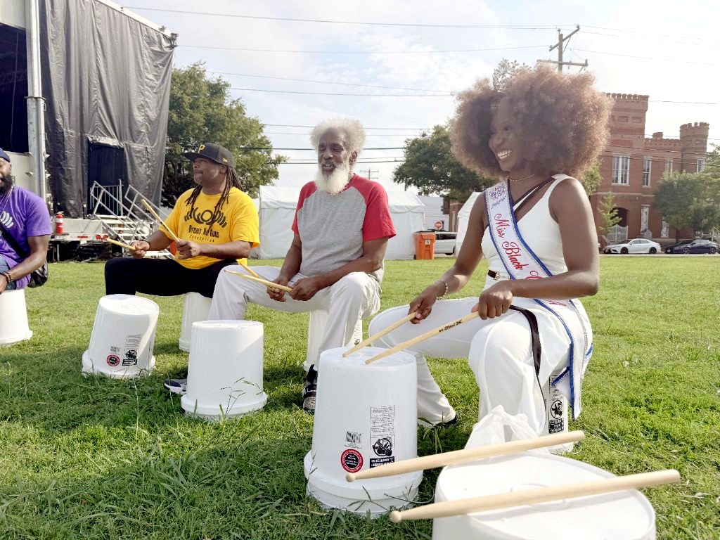 Miss Black USA 2026 Harmony Edosomwan smiling in a drum circle at Abner Clay Park